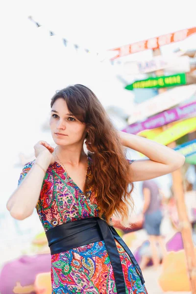 Bela morena em um vestido longo na praia perto do bar ou ir dançar. Conceito de entretenimento e recreação — Fotografia de Stock