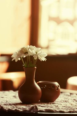 Natürmort. Beyaz masa örtüsü Restoran koridorda bir masada bir kahverengi kil vazo krizantem ile standları
