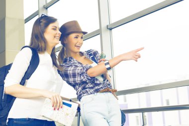 İki genç kız haritaya bakın ve işaret parmağı yön göstermek