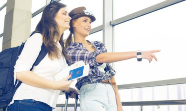 İki genç kız haritaya bakın ve işaret parmağı yön göstermek