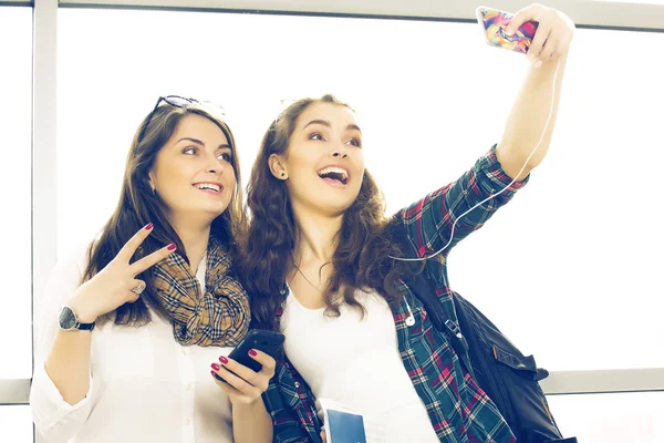 Dwóch turystów młodych kobiet posiadających paszport i zrobić selfie terminali — Zdjęcie stockowe