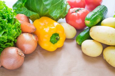 taze sebze. Domates, patates, salatalık, biber, soğan, marul, havuç, lahana kağıt bir masada