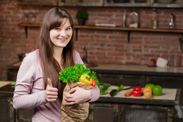 Wanita muda yang bahagia dengan sayuran di tas belanja. Gadis cantik di dapur Memasak makanan sehat. Konsep Diet — Stok Foto