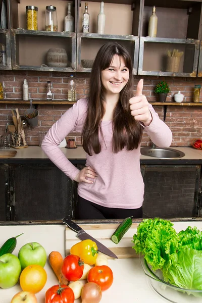 Μια γυναίκα κόβει ένα αγγούρι στην κουζίνα με ένα μαχαίρι. Προετοιμασία της σαλάτας και υγιεινά τρόφιμα. — Φωτογραφία Αρχείου