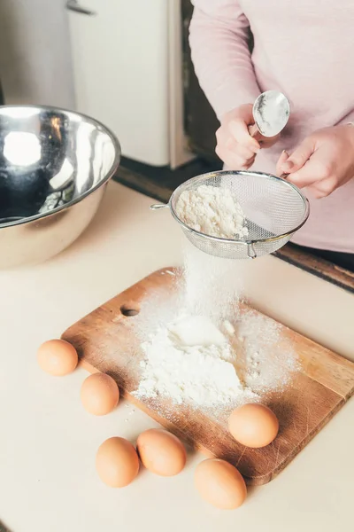 ふるいにかけた小麦粉を台所のテーブルにふるいの上に女性の手のクローズ アップ. — ストック写真