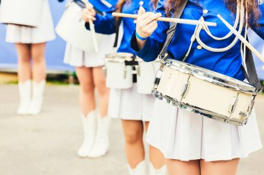 A female music band with drums. Female feet. Women in uniform play the drums at the ceremony clipart