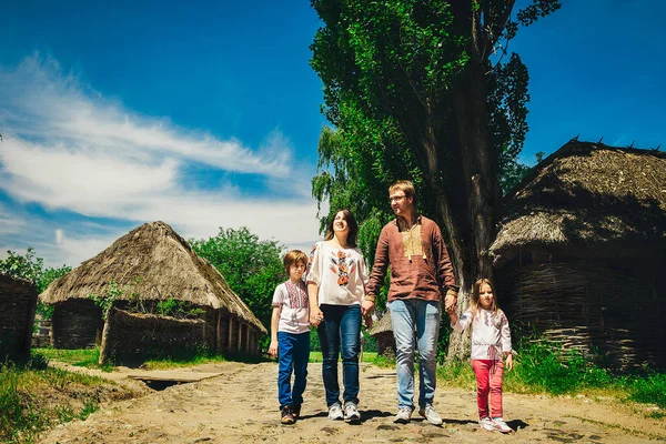 Щасливі Українська родина з маленький син і дочка у традиційний одяг українських в сільській місцевості, парк. — стокове фото