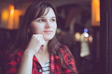 Kafede kırmızı Kareli gömlekli uzun saçlı ciddi kız çok esmer modeli.