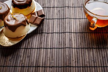 Koyu ahşap arka plan üzerinde çay pasta. Çikolata sır süzme peynir tatlısı