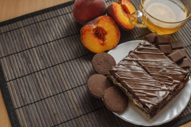 Koyu ahşap arka plan üzerinde çay pasta. Çikolata sır süzme peynir tatlısı