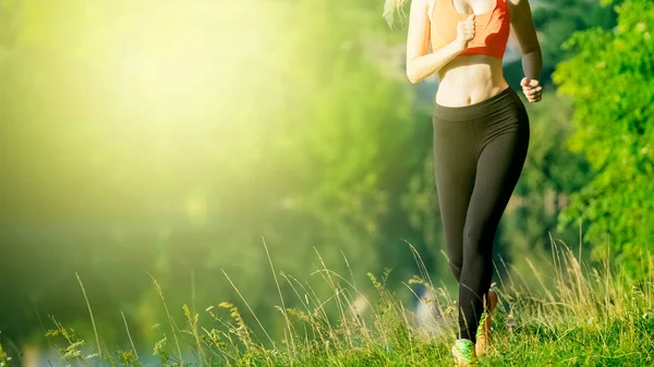 doğa üzerinde çalışan genç sarışın bir kadın. Bir kırmızı bir spor kız T-shirt Nehri yakınında park boyunca çalışır.