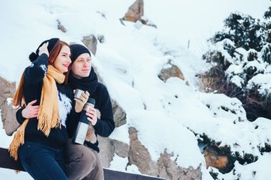 Genç çift termos içinde kış orman sıcak çay dökülen