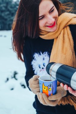 Genç çift ahşap aşık. Adam bir termos çay dökülen. Yakın çekim