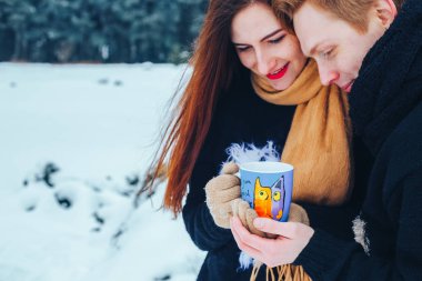 Genç çift ahşap aşık. Adam bir termos çay dökülen. Yakın çekim