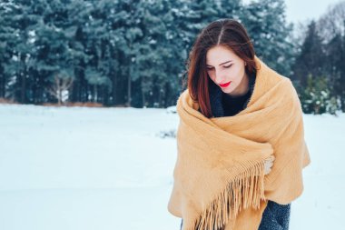 bir kış orman içinde kırmızı bir fular olan Kızıl saçlı kadın