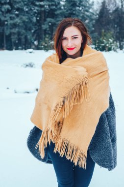 bir kış orman içinde kırmızı bir fular olan Kızıl saçlı kadın