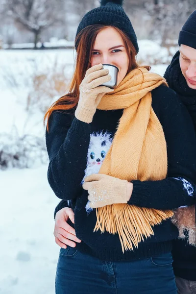 Genç çift termos içinde kış orman sıcak çay dökülen