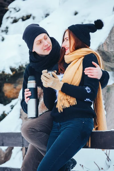 Genç çift termos içinde kış orman sıcak çay dökülen