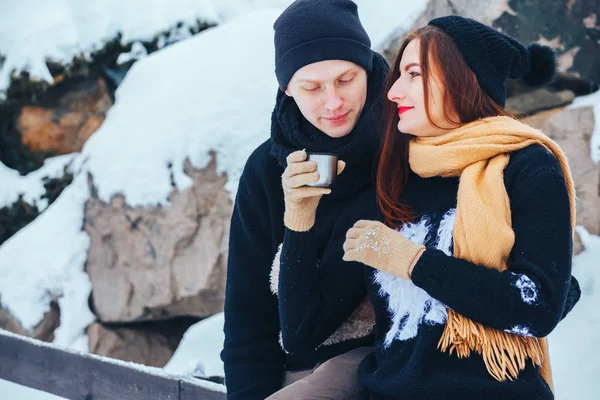 Genç çift termos içinde kış orman sıcak çay dökülen