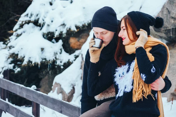 Genç çift termos içinde kış orman sıcak çay dökülen