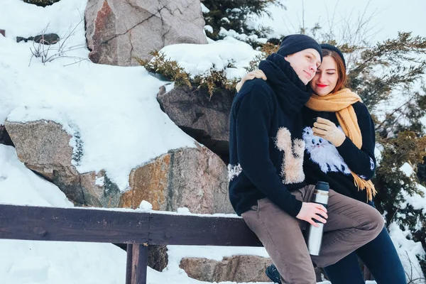 Genç çift termos içinde kış orman sıcak çay dökülen