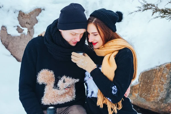 Genç çift termos içinde kış orman sıcak çay dökülen