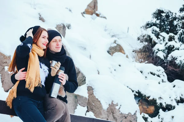 Genç çift termos içinde kış orman sıcak çay dökülen