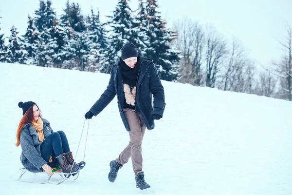 bir kış tatil zevk ve karlı kış gününde eğleniyor aşık genç Çift.