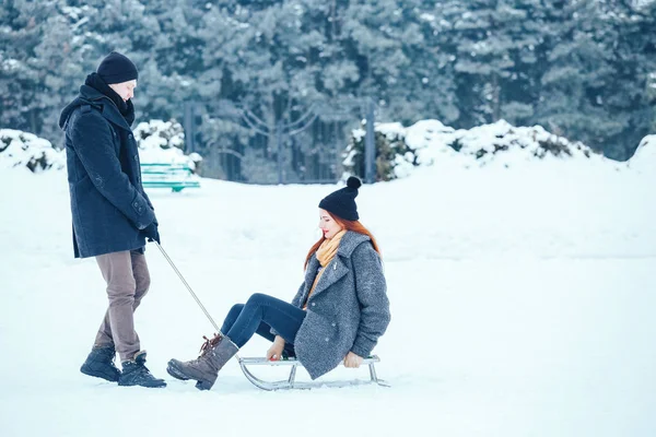 bir kış tatil zevk ve karlı kış gününde eğleniyor aşık genç Çift.