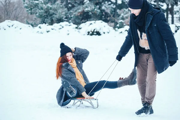 bir kış tatil zevk ve karlı kış gününde eğleniyor aşık genç Çift.
