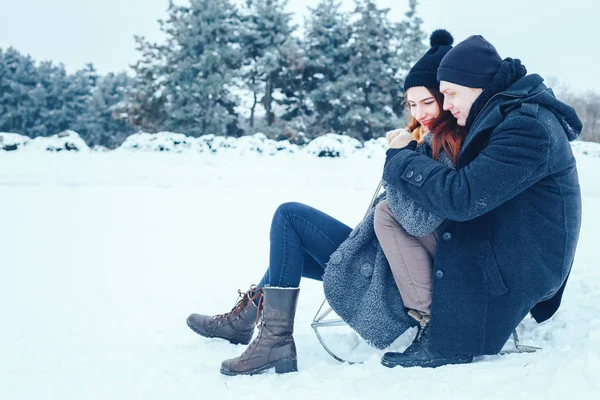bir kış tatil zevk ve karlı kış gününde eğleniyor aşık genç Çift.