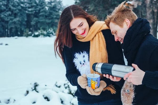 Genç çift ahşap aşık. Adam bir termos çay dökülen. Yakın çekim