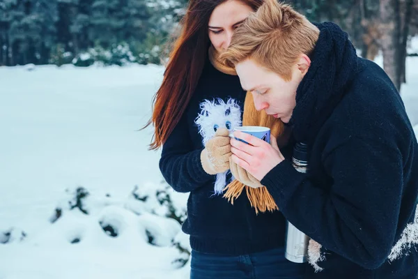 Genç çift ahşap aşık. Adam bir termos çay dökülen. Yakın çekim
