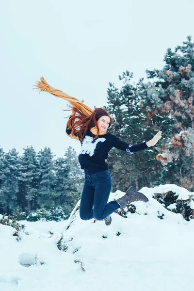 bir kış orman içinde kırmızı bir fular olan Kızıl saçlı kadın