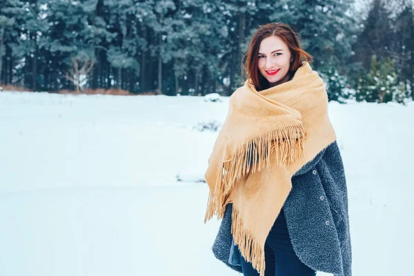 bir kış orman içinde kırmızı bir fular olan Kızıl saçlı kadın