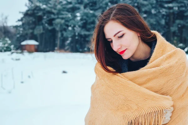 bir kış orman içinde kırmızı bir fular olan Kızıl saçlı kadın