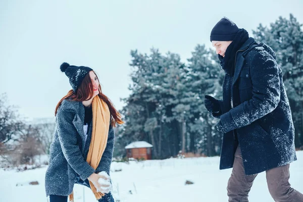 Adam ve kız kış ormanlarında dinleniyorlar. Karda karı-koca. Genç bir çift kış parkında yürüyor..