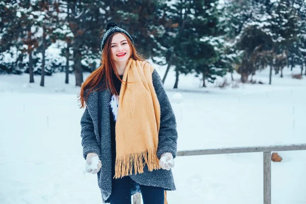 bir kış orman içinde kırmızı bir fular olan Kızıl saçlı kadın