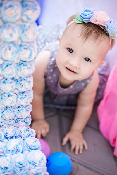 Baby girl in a blue dress with a hoop on her head. — Stock Photo, Image