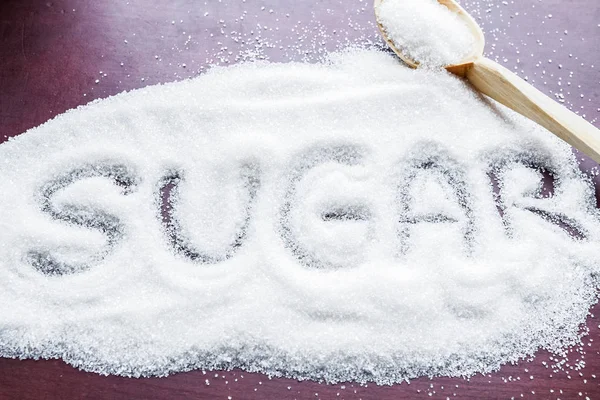 White sugar. White sugar with sugar word on dark background — Stock Photo, Image