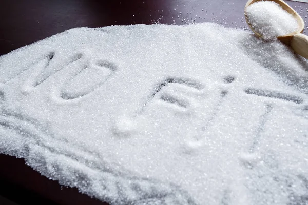 The word NO FIT written on a covered sugar and a wooden spoon on the table. — Stock Photo, Image