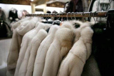 Doğal kürk mantolar bir mağazada askılarda asılı durur. Kışın sıcak tutacak giysi satışı. Türk dükkanı