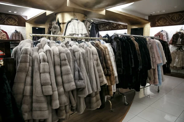 Naturliga pälsar hänga på hängare i en butik. Försäljning av varma vinterkläder. Turkisk butik — Stockfoto