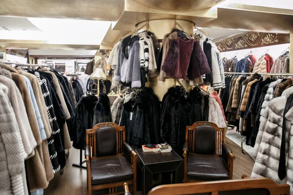 natural fur coats hang on hangers in a store. Sale of winter warm clothes. Turkish shop