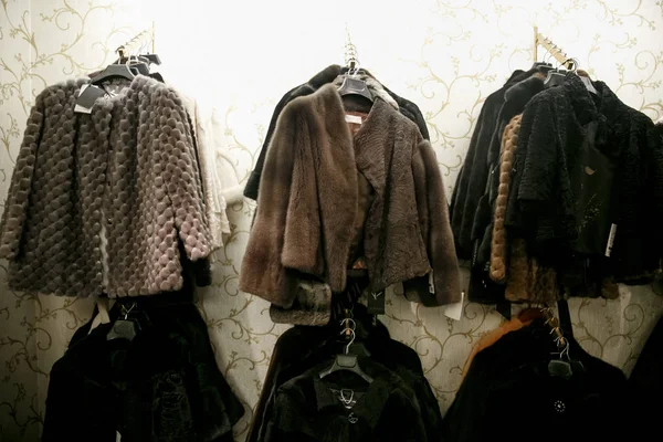 Natural fur coats hang on hangers in a store. Sale of winter warm clothes. Turkish shop — Stock Photo, Image