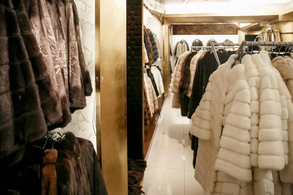 Natural fur coats hang on hangers in a store. Sale of winter warm clothes. Turkish shop — Stock Photo, Image