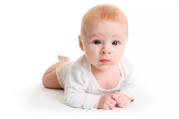 Pequeno Bebê Meses Está Deitado Uma Superfície Branca Olhando Para — Fotografia de Stock