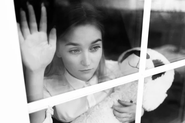 Beyaz Bluzlu Sağlık Maskeli Genç Sarışın Bir Kız Pencerenin Dışında — Stok fotoğraf
