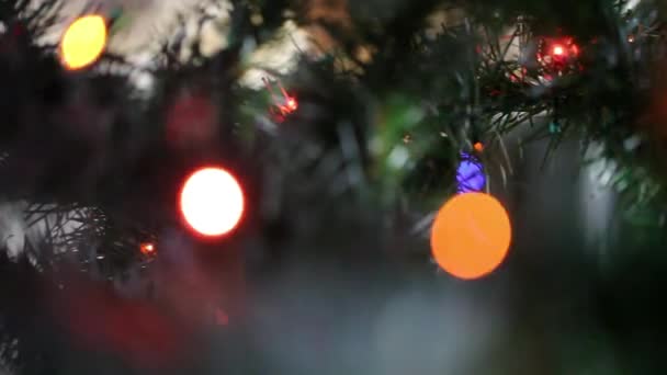 Navidad y Año Nuevo Decoración. Una bola amarilla en el árbol de Navidad. Fondo de luces de hadas. La cámara se mueve de izquierda a derecha . — Vídeo de stock