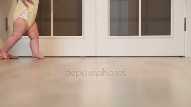 彼の最初のステップを歩いて赤ちゃん 白い木製ドア Background Mother 最初の手順を実行する彼女の子供を教えています 足のクローズ アップ — ストック動画